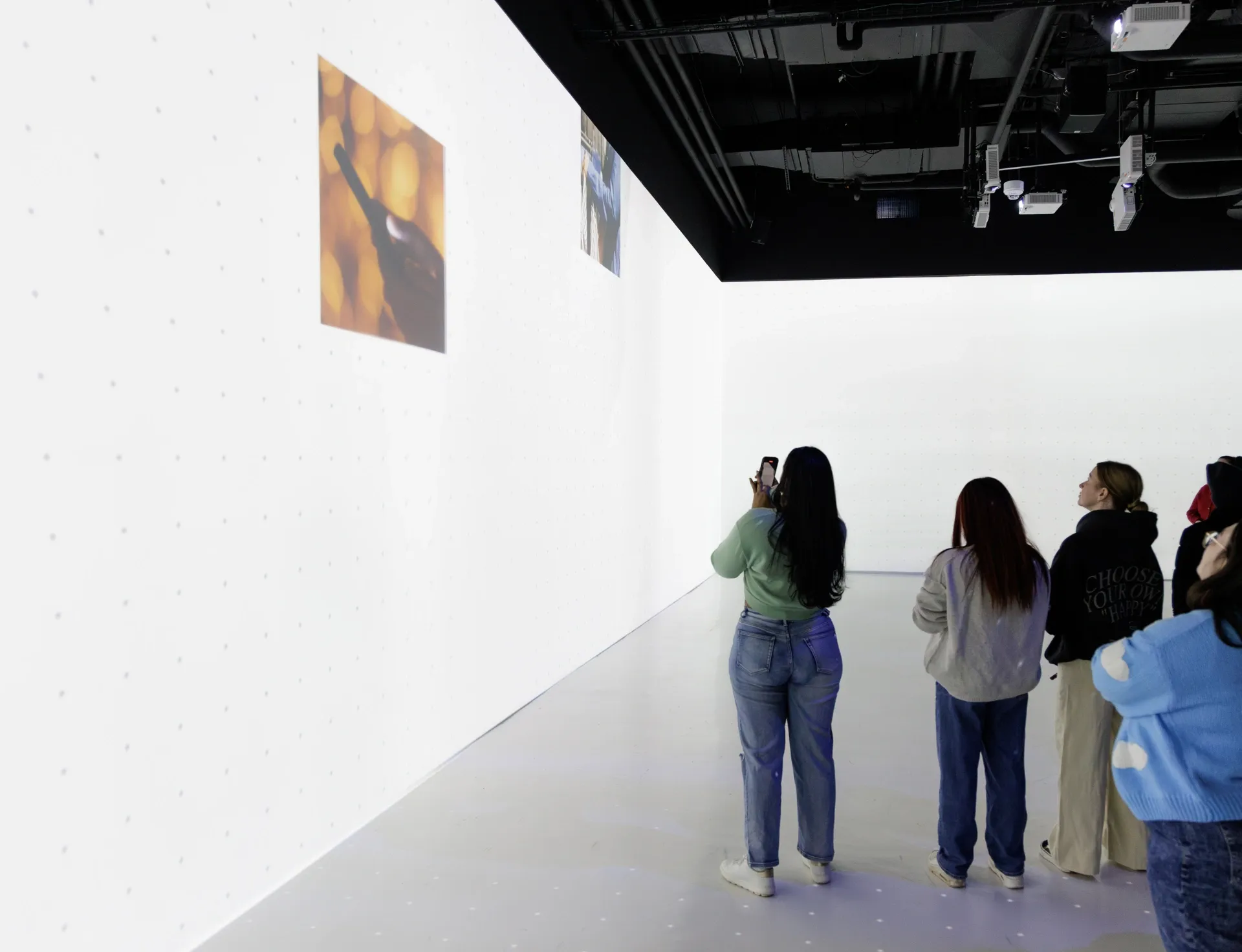 People in a projection room, dark and lit up on the walls