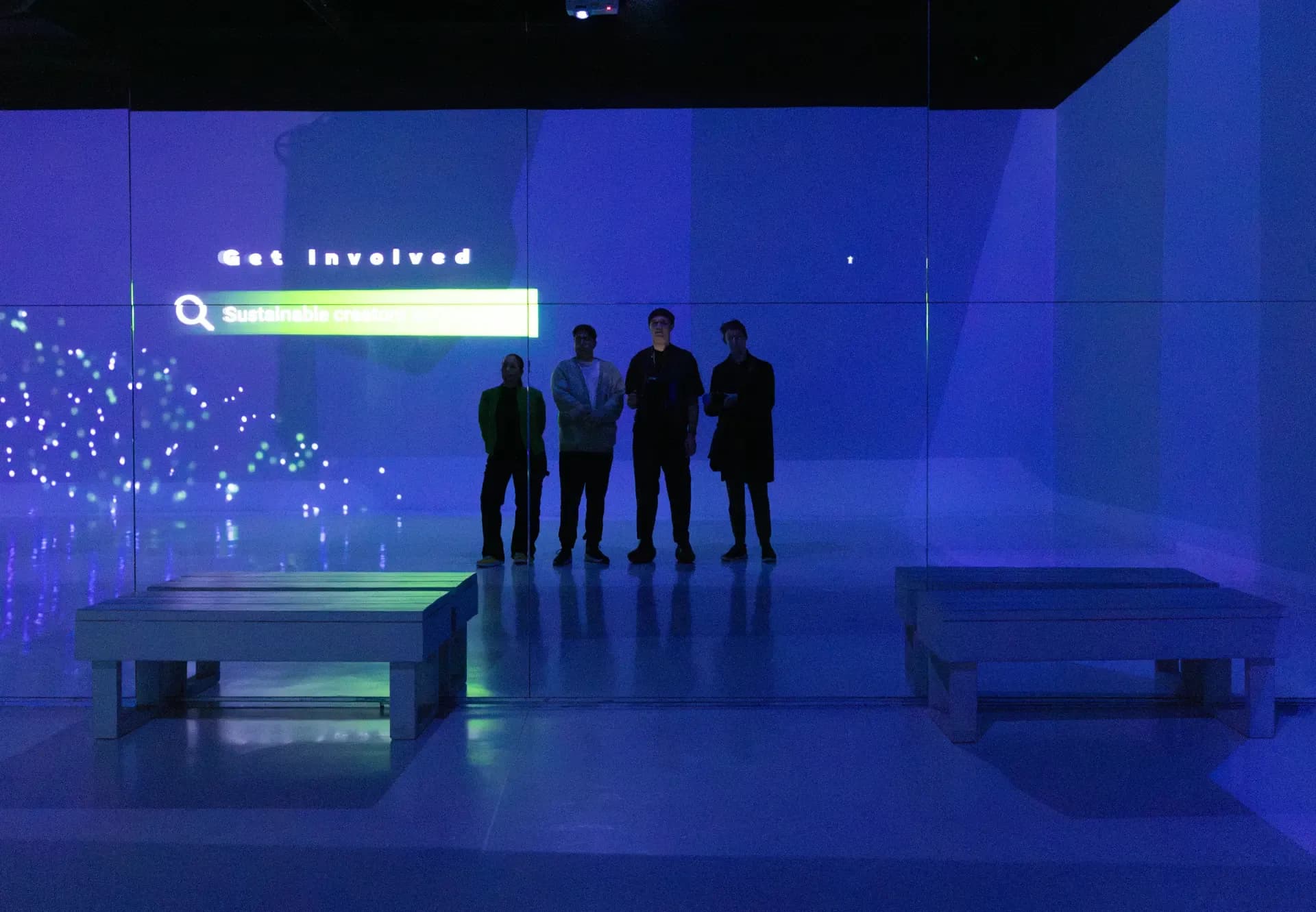 People in a projection room, dark and lit up on the walls, blue