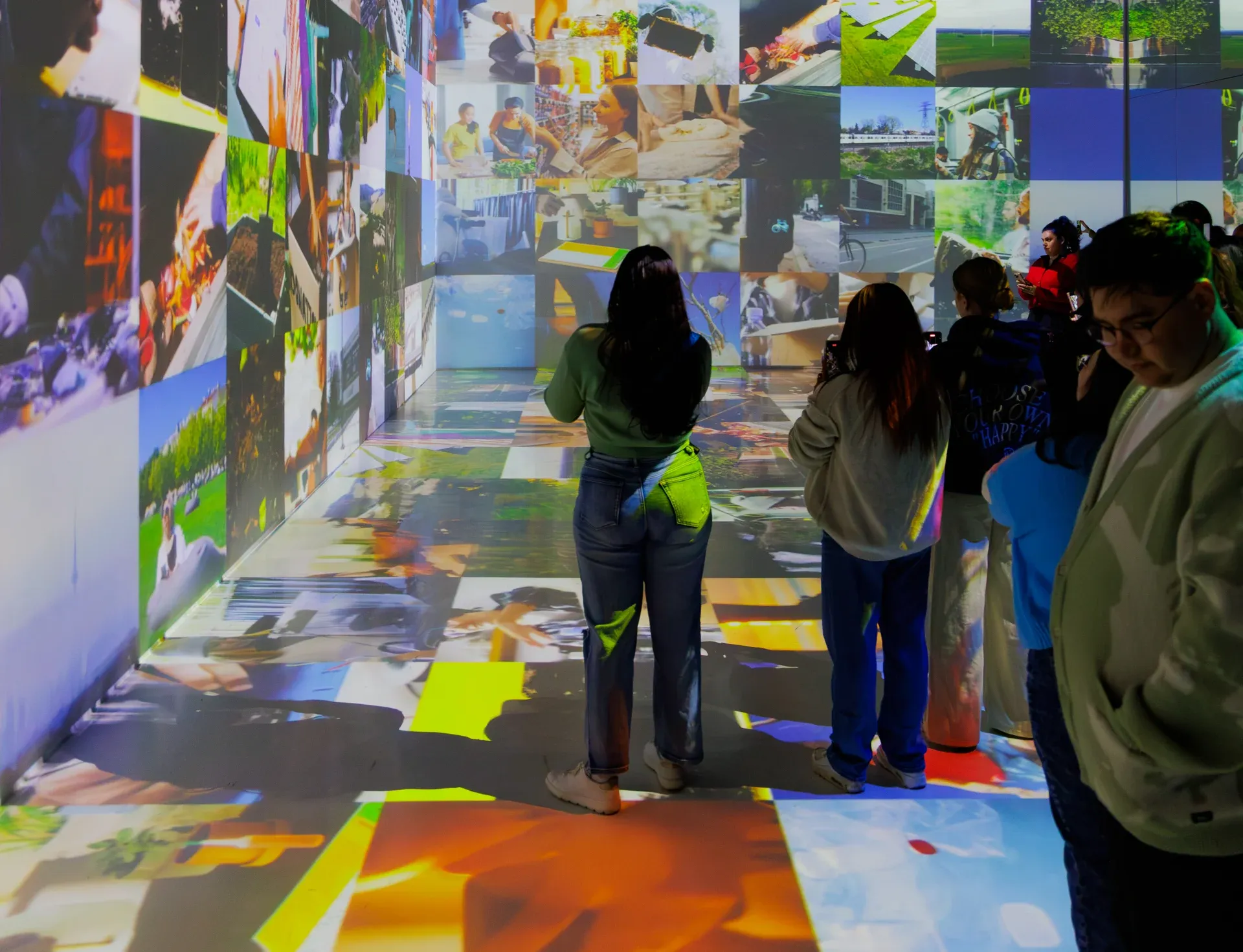 People in a projection room, dark and lit up on the walls